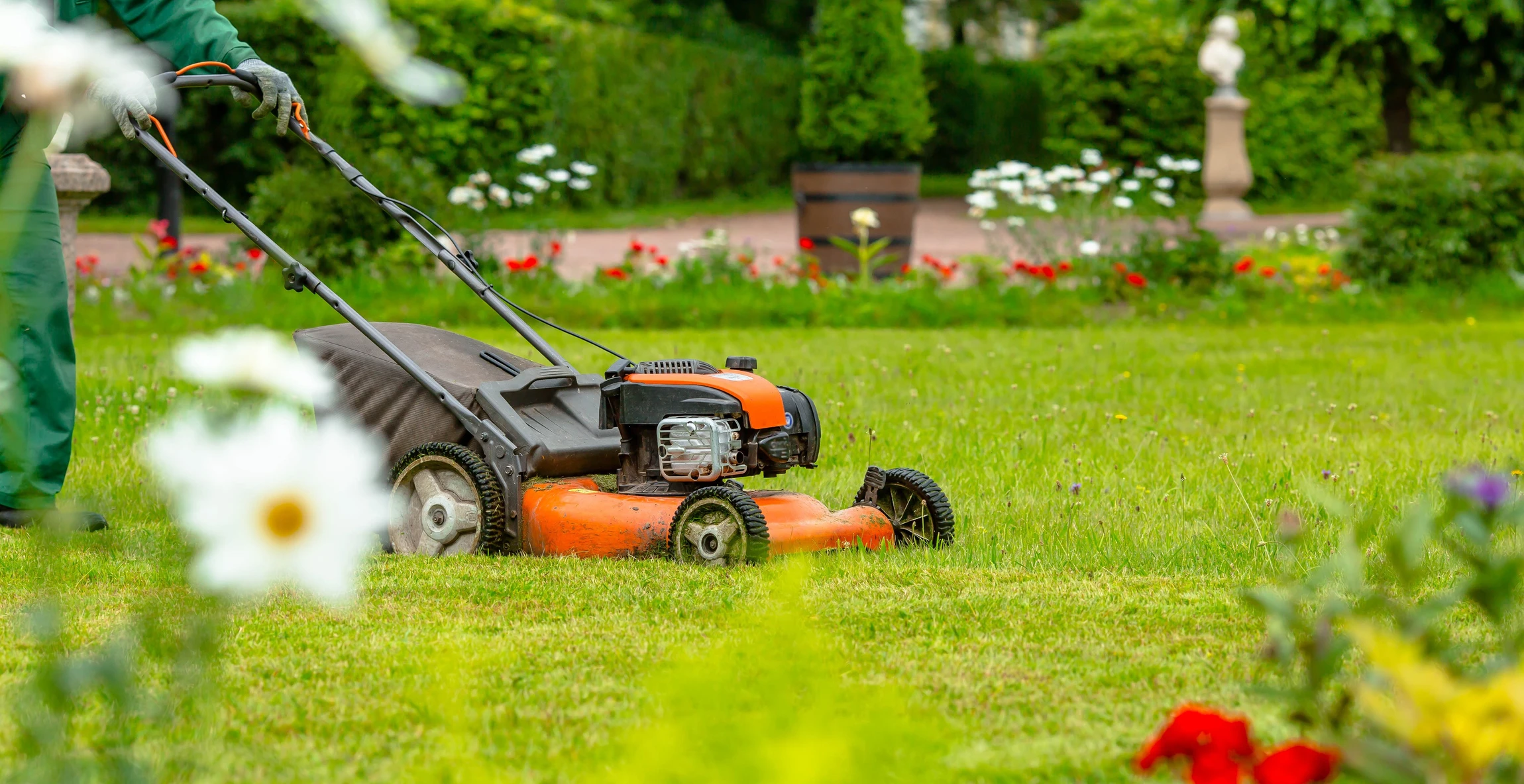 Scène extérieure de jardinage professionnel dans un parc avec pelouse verte et massifs fleuris colorés